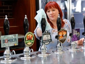 A member of staff at a Wetherspoons pub in north London cleans the bar in preparation for pubs to reopen early next month on June 24, 2020.