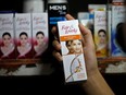 A customer picks up "Fair & Lovely" brand of skin lightening product from a shelf in a shop in Ahmedabad, India, Thursday, June 25, 2020.