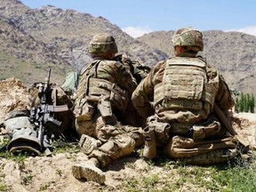 In this file photo taken on June 6, 2019 U.S. soldiers look out over hillsides at the Afghan National Army (ANA) checkpoint in Nerkh district of Wardak province.