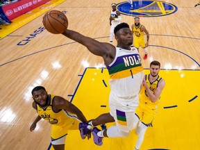 February 23, 2020; San Francisco, California, USA; New Orleans Pelicans forward Zion Williamson (1) dunks the ball against Warriors forward Eric Paschall (7) and centre Dragan Bender (10) during NBA action at Chase Center.