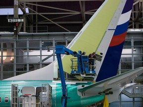 Boeing employees work on the tail of a Boeing 737 NG at the Boeing plant in Renton, Washington December 7, 2015.
