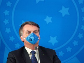 Jair Bolsonaro President of Brazil wears a protective mask during a press conference about outbreak of the coronavirus (COVID - 19) at the Planalto Palace on March 20, 2020 in Brasilia, Brazil.