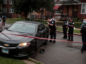 Police investigate the scene of a shooting in the Auburn Gresham neighbourhood on July 21, 2020 in Chicago, Illinois. At least 14 people were transported to area hospitals after several gunmen, believed to be in this bullet-riddled car, opened fire on mourners standing outside a funeral home.