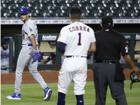 Joe Kelly of the Los Angeles Dodgers has a word with Carlos Correa of the Houston Astros as he walks off the mound after a series of high inside pitches in the sixth inning at Minute Maid Park on July 28, 2020 in Houston, Texas. Both benches emptied.