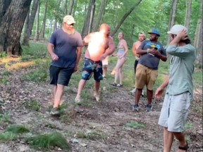 Vauhxx Booker (second from right) is seen with an acquaintance (right) before what Booker said was an assault on him by several white men threatening to lynch him, before a group of bystanders and friends intervened to stop the attack, at Lake Monroe, Ind., July 4, 2020, in this still image taken from video obtained from social media.