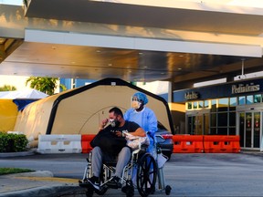 A nurse takes a patient to their car from Memorial West Hospital where coronavirus disease (COVID-19) patients are treated, in Pembroke Pines, Florida, July 13, 2020.
