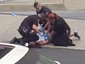 Police officers attempt to restrain a man outside hospital's emergency department in Allentown, Pennsylvania, July 11, 2020 in this still image taken from a video.