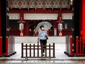 A woman wearing a protective face mask walks at a shrine amid the coronavirus disease outbreak, in Tokyo, Japan July 15, 2020.