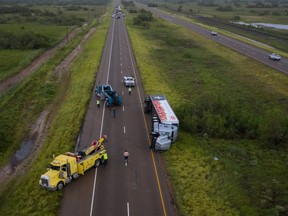 Traffic is halted as tow trucks surround an overturned HEB supermarket truck along US Route 77 in the aftermath of high wind gusts from Hurricane Hanna in Sarita, Texas, U.S., July 26, 2020.