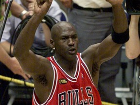 Chicago Bulls Michael Jordan holds up six fingers as he walks around the court after the Bulls defeated the Utah Jazz 87-86 to win the NBA championship in Salt lake City June 14, 1998.