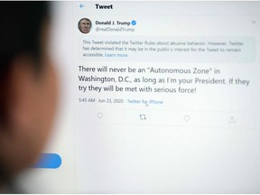 This illustration photo shows a woman in Los Angeles looking at the official Twitter account of US President Donald Trump on June 23, 2020, with a tweet by the president which Twitter considered "abusive" and hid it.