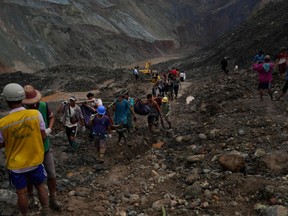 Rescuers recover bodies near the landslide area in the jade mining site in Hpakhant in Kachin state on July 2, 2020.