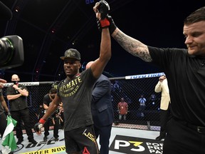 A handout image released by the Ultimate Fighting Championship (UFC) on July 12, 2020, shows Nigeria's Kamaru Usman, left, has his hand raised after winning the welterweight championship fight during the UFC 251 event at UFC Fight Island in Abu Dhabi's Yas Island.