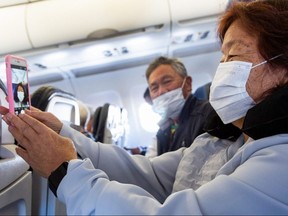 A passenger takes a selfie while wearing a mask before take-off at the Phoenix International Airport on March 14, 2020 in Phoenix.