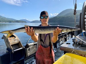 Tyler Vogrig holds up a barracuda caught in Alberni Inlet on Vancouver Island on July 5, 2020 in a handout photo.