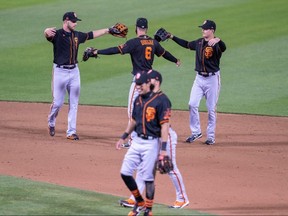 San Francisco Giants outfielders Steven Duggar (6), Mike Yastrzemski (5) and Austin Slater (13) pretend to hug while celebrating a win over the Oakland Athletics at Oakland Coliseum.