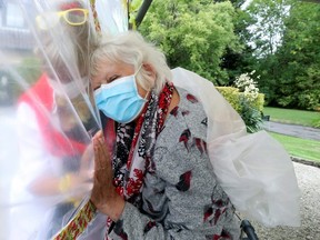 Lily Hendrickx, 83, a resident at Belgian nursing home  "Le Jardin de Picardie"  enjoy hugs and cuddles with Marie-Christine Desoer, the director of the residence, through a wall made with plastic sheets to protect against potential coronavirus disease (COVID-19) infection, in Peruwelz, Belgium July 1, 2020.