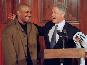 U.S. President Bill Clinton accepts a Florida Marlins jersey from Marlins third baseman Bobby Bonilla at a ceremony honouring the World Series winning team, in Washington, D.C., Feb. 17, 1998.