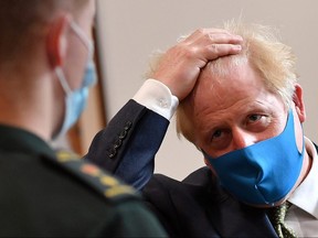 Britain's Prime Minister Boris Johnson talks with a paramedic as he visits headquarters of the London Ambulance Service NHS Trust in London July 13, 2020.
