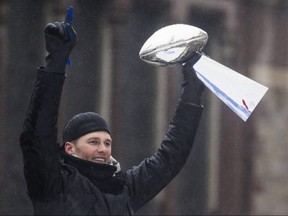 Tom Brady of the New England Patriots hoists the Vince Lombardi Trophy during a Super Bowl victory parade on February 7, 2017 in Boston.