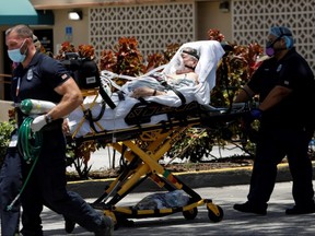 Emergency Medical Technicians leave with a patient at Hialeah Hospital where COVID-19 patients are treated, in Hialeah, Fla., Wednesday, July 29, 2020.