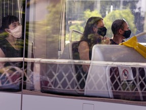 Toronto Transit Commission riders wear masks as they ride a streetcar in Toronto on Thursday, July 2, 2020.