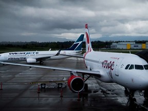 A Westjet Boeing 737-800, left, taxis past an Air Canada Rouge Airbus A319 at Vancouver International Airport in Richmond, B.C., on Monday, April 28, 2014.