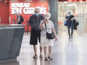People wear face masks as they walk through Central Station in Montreal, Sunday, July 19, 2020, as the COVID-19 pandemic continues in Canada and around the world.