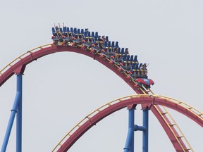 People wear face masks as they ride 'The Goliath', roller coaster at La Ronde amusement park in Montreal, Saturday, July 25, 2020, as the COVID-19 pandemic continues in Canada and around the world.