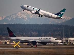 An Air Canada flight departing for Toronto, bottom, taxis to a runway as a Westjet flight bound for Palm Springs takes off at Vancouver International Airport, in Richmond, B.C., Friday, March 20, 2020.