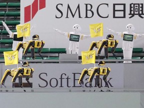 SoftBank Corp's humanoid robots Pepper and Boston Dynamics' robots SPOT in baseball uniforms cheer the team next to empty seats at a game between SoftBank Hawks and Tohoku Rakuten Golden Eagles in Fukuoka, Japan in this photo taken by Kyodo July 7, 2020.