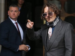 Johnny Depp waves as he arrives on the second day of his libel trial against News Group Newspapers (NGN), at the High Court in London, on July 8, 2020.