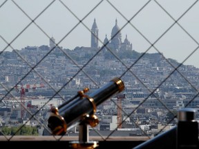A view shows a telescope at the Eiffel Tower with the Sacre-Coeur Basilica of Montmartre in the background, in Paris on its reopening day to the public following the coronavirus outbreak in France, June 25, 2020.