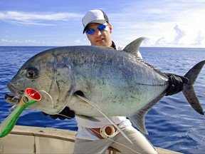 Fisherman holding a big Trevally jack.