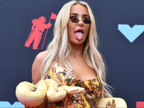 US internet personality Tana Mongeau holds a snake as she arrives for the 2019 MTV Video Music Awards at the Prudential Center in Newark, New Jersey on August 26, 2019.