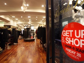 A sign advertises extended early morning opening hours on the door of the Brooks Brothers clothing store in Regent Street on Nov. 28, 2008 in London, England.