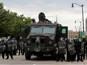 Detroit police, wearing riot gear, line up next to an armored vehicle in preparation to enforce a curfew following a rally against the death in Minneapolis police custody of George Floyd, in Detroit, Michigan, U.S. June 1, 2020.