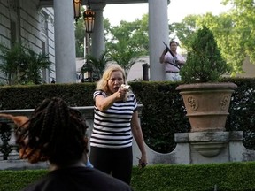 Patricia McCloskey and her husband Mark McCloskey draw their firearms on protestors, including a man who holds a video camera and microphone, as they enter their neighborhood during a protest against St. Louis Mayor Lyda Krewson, in St. Louis, Missouri, U.S. June 28, 2020.