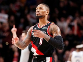 Portland Trail Blazers guard Damian Lillard (0) gestures after making a three point basket  against the Golden State Warriors during the second half at Moda Center.