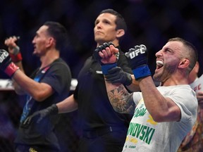 Alexander Volkanovski (blue gloves) reacts after defeating Max Holloway (red gloves) during UFC 245 at T-Mobile Arena in Las Vegas.