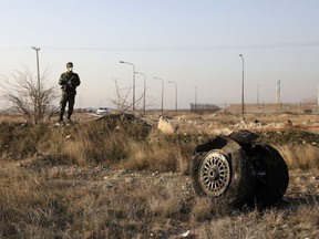 A police officer stands guard as debris is seen from an Ukrainian plane which crashed in Shahedshahr, southwest of the capital Tehran, Iran, January 8, 2020.