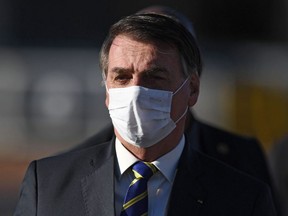 Brazilian President Jair Bolsonaro wears a face mask as he arrives at the flag-raising ceremony before a ministerial meeting at the Alvorada Palace in Brasilia, Brazil, amid the COVID-19 pandemic, May 12, 2020.