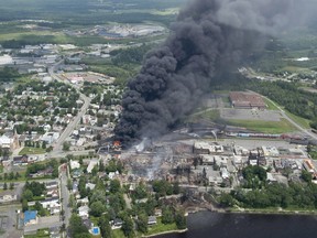Smoke rises from railway cars that were carrying crude oil after derailing in downtown Lac-Mégantic, Que., Saturday, July 6, 2013. Lac-Megantic will mark the seventh anniversary of a tragic rail disaster that claimed 47 lives by inaugurating a long-planned memorial space.