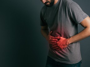 Young man suffering from stomach ache standing