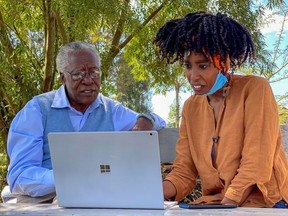 Chao Tayiana, a digital historian, and her grandfather Daniel Sindiyo, whose mother was in the British detention camps of the pre-independence Mau Mau rebellion, look at the reconstructed 3D models of the detention camps, during a Reuters interview in Ngong, outside Nairobi, Kenya June 29, 2020.