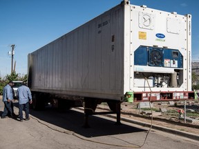 Men unload a mobile morgue outside the El Paso County Office on July 21, 2020 in El Paso, Texas.