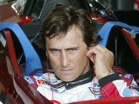 Italian driver Alex Zanardi uses his ear sticks before sitting in the cockpit of his specially modified car at the Eurospeedway Lausitzring circuit in the eastern German town of Klettwitz May 11, 2003, before the German 500 CART race.