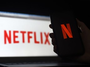 In this file photo illustration a computer and a mobile phone screen display the Netflix logo on March 31, 2020 in Arlington, Virginia.
