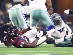 Texans running back Lamar Miller (26) grabs his knee during a play in the first quarter against the Cowboys during preseason action at AT&T Stadium, in Arlington, Texas, Aug. 24, 2019.