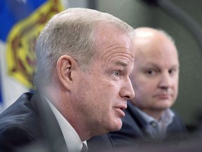 Then-Attorney General Mark Furey, left, fields a question as Bret Mitchellin, CEO of the Nova Scotia Liquor Corporation, looks on at a news conference in Halifax, Tuesday, Jan. 30, 2018.